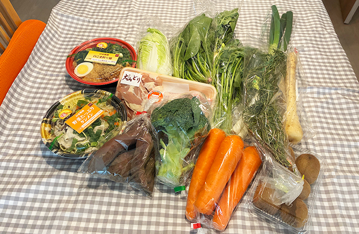 人参３本、ブロッコリー、さつまいも、キウイの大袋とホウレンソウ、白菜、長ネギ、長芋、コンビニラーメン2個が並んでいる写真